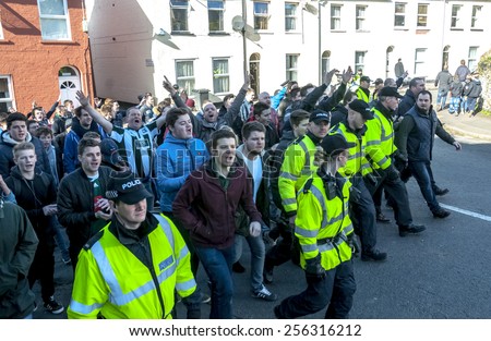 EXETER, ENGLAND - FEBRUARY 21, 2015: Devon and Cornwall Police escort Plymouth football fans  during the police operation at the League 2 football match between Exeter City FC and Plymouth Argyle FC
