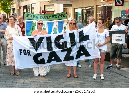 EXETER, ENGLAND - JULY 15, 2014: Peace protesters hold a banner, which says \'Vigil for Gaza\' during the Peace Vigil for Gaza in Exeter\'s Princesshay Square.