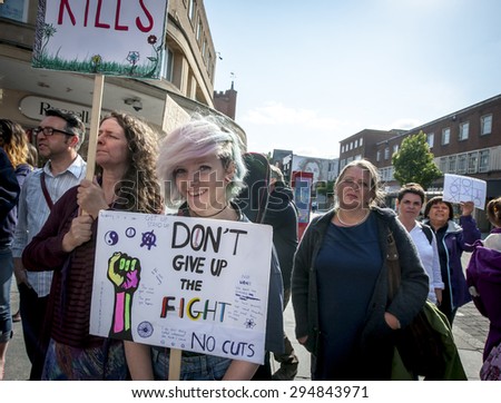 EXETER - JULY 8: A young woman holds a placard which says 