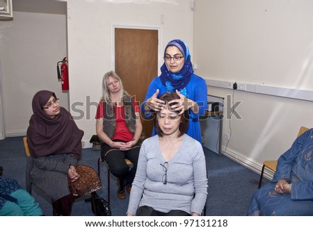EXETER - MARCH 8 : Nazima Khan performing Indian head massage at the International Women\'s Day event at the St Sidwell\'s Centre in Exeter,  Devon  on March 8, 2012 in Exeter Devon uk