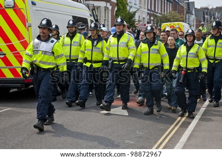 EXETER - APRIL 30: Devon and Cornwall Police escort football fans to prevent football violence at the League 1 match between Exeter City FC and Plymouth Argyle FC on April 30, 2011 in Exeter, UK.