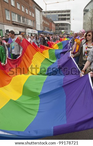 EXETER - MARCH 31: Festival goers hold the rainbow banner at the Exeter Pride 2012 Parade in Exeter City centre  on March 31, 2012 in Exeter, UK