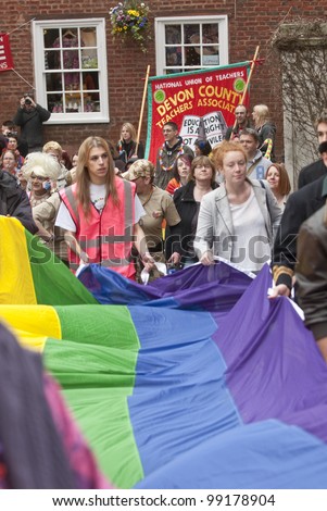 EXETER - MARCH 31: Festival goers hold the rainbow banner at the Exeter Pride 2012 Parade in Exeter City centre  on March 31, 2012 in Exeter, UK