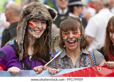 EXETER - MARCH 31: Festival goers have a laugh & hold up the Exeter Pride banner at the Exeter Pride 2012 Parade in Exeter City centre on March 31, 2012 in Exeter, UK