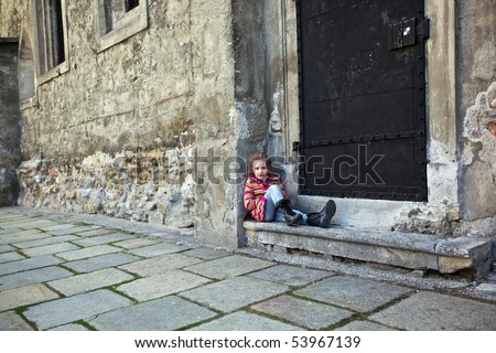 a girl sitting on steps on old wall background