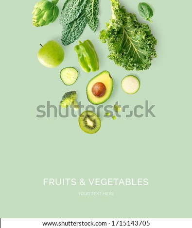 Creative layout made of kale, broccoli, green beans, zucchini, cucumber, apple, kiwi, lemongrass  on the green background. Flat lay. Food concept. Macro  concept. Foto stock © 