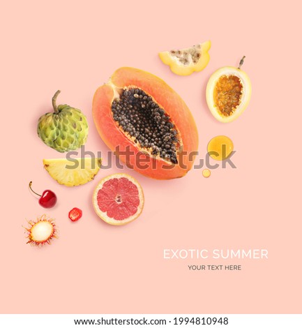Creative layout made of summer fruits.  Tropical flat lay. Food concept. Papaya, pineapple, grapefruit, cherry, rambutan, sugar apple and passion fruit on the pink background.