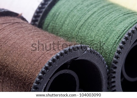 Close-up photograph of a brown spool of thread among other spools.