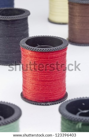 Close-up photograph of a red spool of thread among other spools.