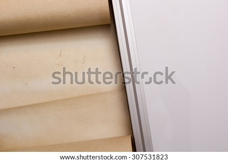 The parchment is rolled into a scroll, next to the board of plastic.