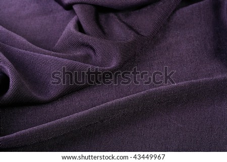 Darkly violet fabric as a background, is used in a clothing industry.