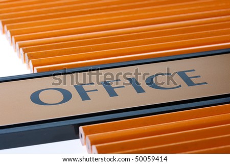 The tablet with a word office on a table among pencils for work at office.