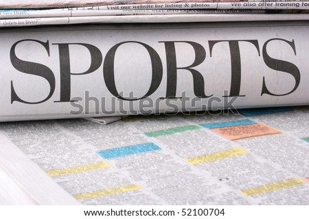 The sports newspaper together with other newspapers on a table.