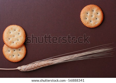 Round cookies on a brown background with a wheaten ear.