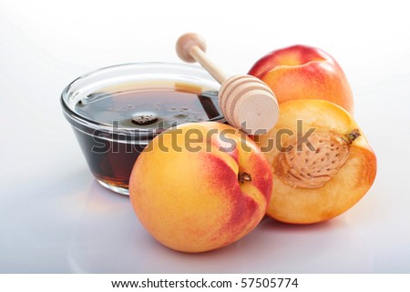 Smooth peaches and honey on a white background.