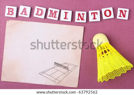 A yellow synthetic badminton shuttlecock next to a piece of paper. Add your text to the paper.