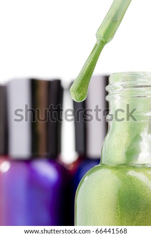 Nail polish brush next to a bottle with green nail polish.