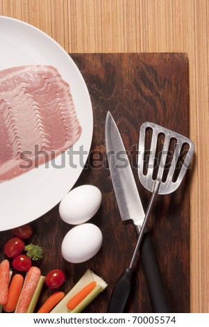 Eggs with vegetables and kitchen items on the kitchen table.