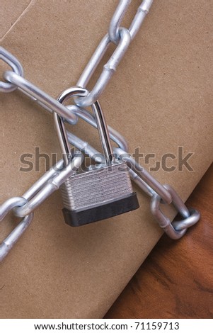 Metal lock and chain on a brown background.