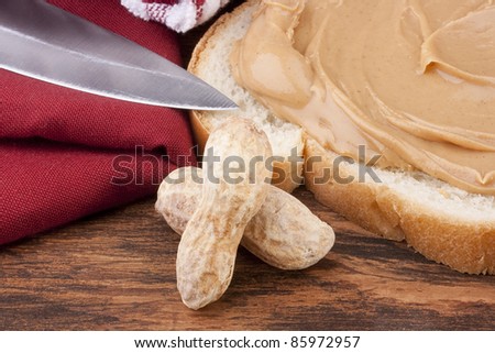 Bread is smeared Peanut butter - a component for a sweet sandwich.