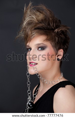 Portrait of a beautiful blonde woman biting a chain/beauty bitting