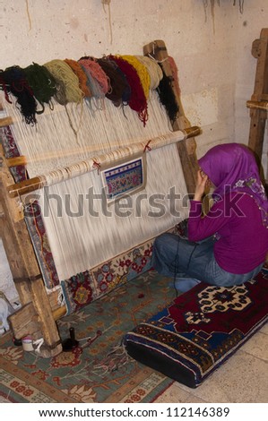 UCHISAR, TURKEY - SEPTEMBER 1, 2012: Islamic woman making a rug at Gallery Cappadocia on September 1, 2012.  Gallery Cappadocia is preparing to enter another International Carpet Competition.