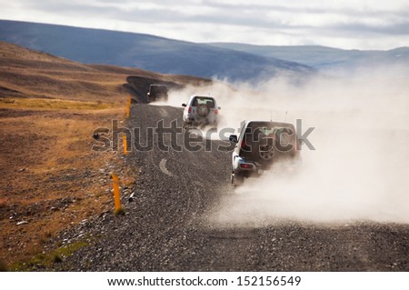 Iceland black road with cars making dust