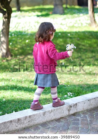 Little girl walking with a bouquet of white flowers in her hand