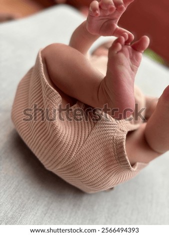 Similar – Image, Stock Photo Baby reaching for feet, dimpled baby hands, triangle print blanket and pants