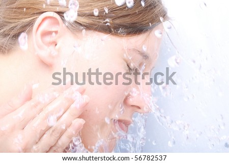 washing face with water splashing (close up)