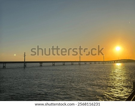 Similar – Foto Bild Gegenlichtlandschaftsbild mit Brücke, Fluss und Strommast