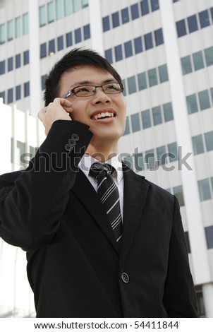 A young Asian businessman speaking on the phone