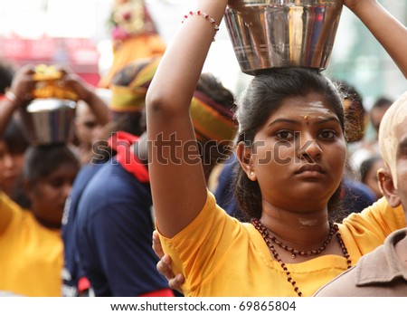 BATU CAVES, MALAYSIA - JANUARY 20:A woman carries a pot of milk during the Hindu festival of Thaipusam on January 20, 2011 in Batu Caves, Malaysia.
