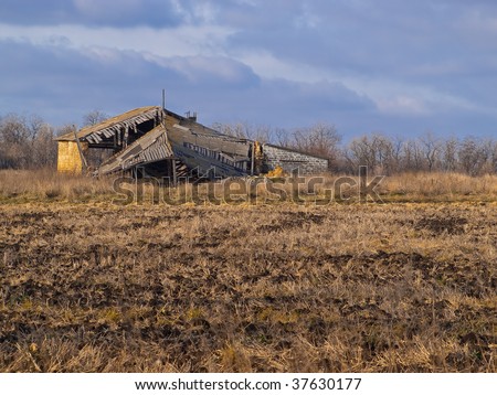 The destroyed house in the middle of a dark autumn field