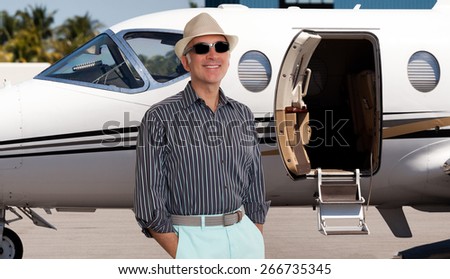 Handsome man standing outside a private jet
