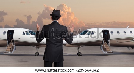 Business man in front of two private jets
