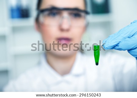 female researcher with glass equipment in the lab - soft focus on glass and hands.