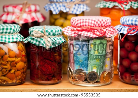 Financial reserves. Money conserved in a glass jar among others preserves. Shallow deep of focus.
