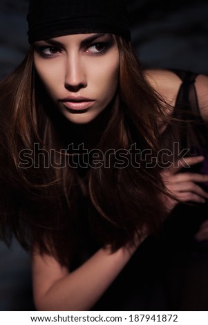 A girl with long hair with a beautiful make-up, small patches of light on the face, expressive eyes and cheekbones