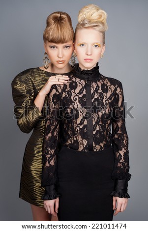 Two fashion models in dress with stylish make-up and hair dress