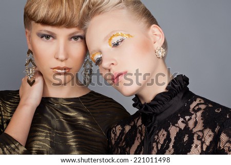 Two fashion models in dress with stylish make-up and hair dress