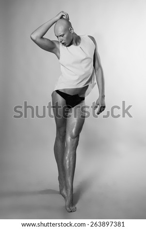 Young man in pants posing on studio background