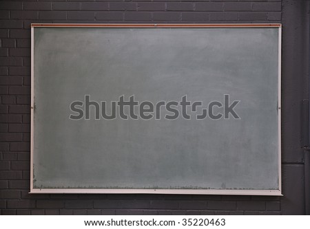 A blank chalk board against a brick wall in a gym