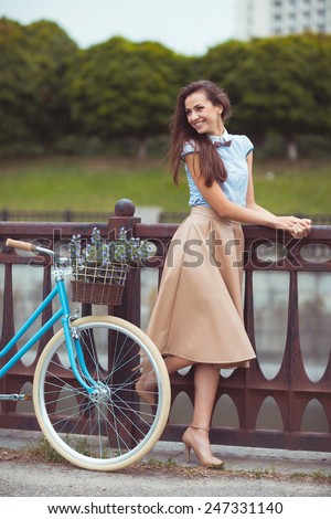 Young beautiful, elegantly dressed woman with bicycle. Beauty, fashion and lifestyle