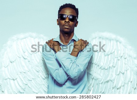 African American young man with angel wings in sunglasses