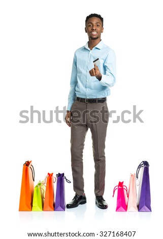 Happy african american man with shopping bags and holding credit card on white. Shopping concept