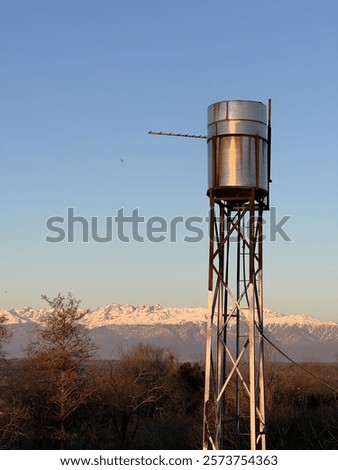 Similar – Image, Stock Photo Vintage water tank on high rusty iron frame in front of grey clouds