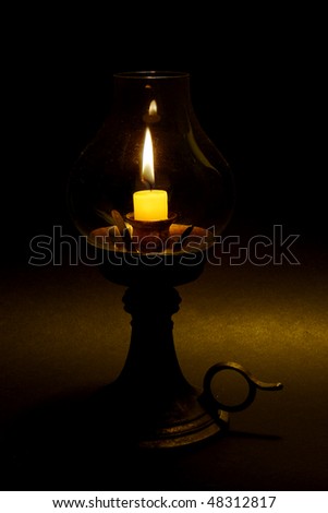 an old candle holder with lit candle