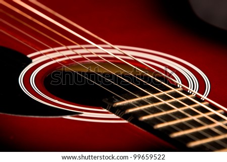 Close up of a five string red guitar.