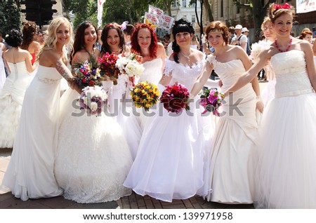 ODESSA, UKRAINE - MAY 26: Annual event Bride Parade. Happy excited participants in fiancee`s gowns take part in celebration of marriage and romance Bride Parade on May 26, 2013 in Odessa, Ukraine